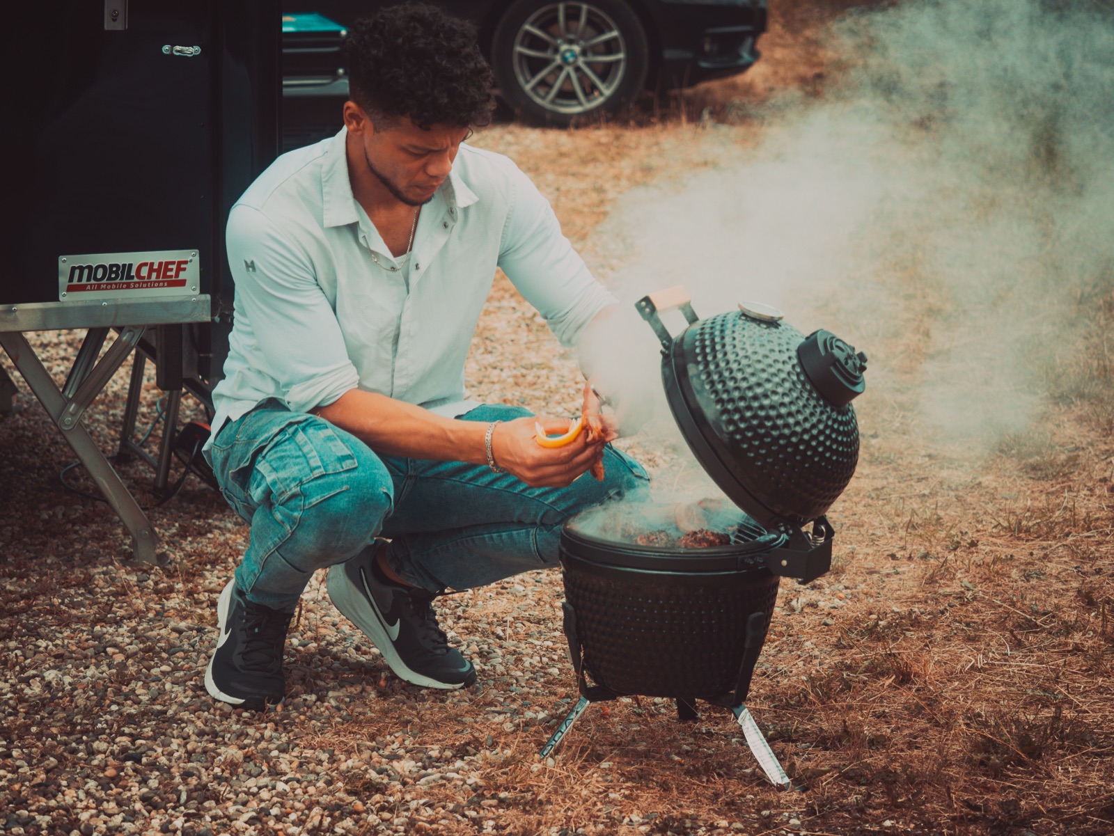 Mello aan het werk bij de grill, rook opstijgend uit de kamado